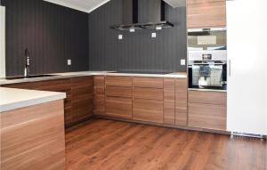 uma cozinha com armários de madeira e pisos de madeira em Lovely Home In Flor With Wifi em Floro