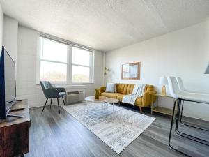 a living room with a couch and a tv at Sleepover Downtown Cincinnati 1BD 1BA Apartments in Cincinnati