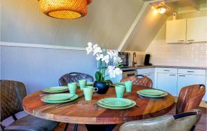 a wooden table with green plates and a vase of flowers at Lovely Home In Gramsbergen With Wifi in Gramsbergen
