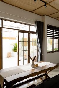 Una habitación con una mesa y una ventana grande. en Natsu No Hanabi Villa & Apartment, en Da Nang