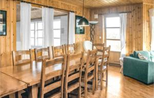 VestvikにあるBeautiful Home In Auklandshamn With 5 Bedrooms, Sauna And Private Swimming Poolのダイニングルーム(木製テーブル、椅子付)