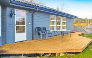 VestvikにあるBeautiful Home In Auklandshamn With 5 Bedrooms, Sauna And Private Swimming Poolのデッキ(テーブル、椅子付)が備わる家