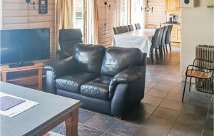 SvenevikにあるStunning Home In Lindesnes With Kitchenのリビングルーム(革張りのソファ、テーブル付)