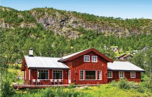 een rood huis in het midden van een berg bij Skarsnuten in Hemsedal