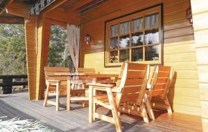 a wooden table and chairs on the porch of a house at Three-Bedroom Holiday Home With A Fireplace In Grisslehamn in Grisslehamn