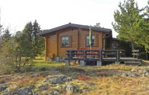 uma cabana de madeira com um alpendre e um banco à sua frente em Beautiful Home In Grisslehamn With Kitchen em Grisslehamn