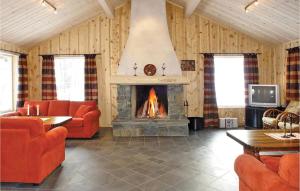 a living room with a fireplace and orange furniture at Skarsnuten in Hemsedal