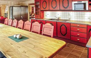 una cucina con tavolo in legno e armadietti rossi di Skarsnuten a Hemsedal
