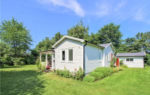 una pequeña casa blanca en un jardín en Beautiful Home In Jonstorp With Kitchen, en Jonstorp