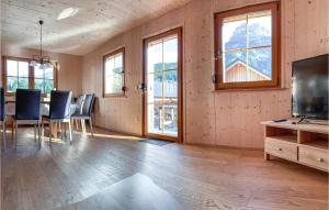 ein Esszimmer mit einem Tisch, Stühlen und Fenstern in der Unterkunft Lovely Home In Altaussee With Sauna in Hinterposern