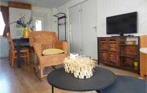 een woonkamer met een tafel en een televisie bij Bungalowpark De Tong in Bruinisse