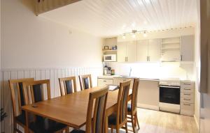 a kitchen with a wooden table and some chairs at Cozy Home In Sysslebck With Kitchen in Branäs