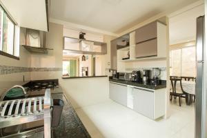 a large kitchen with white cabinets and appliances at Porto das Dunas Casa Temporada Estilo e Conforto in Fortaleza