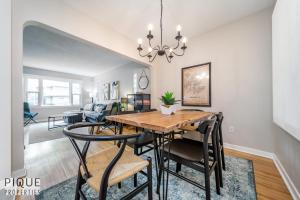 a dining room and living room with a table and chairs at 6 Bed Chic Stylish Home - 5 Mins to U of A & Whyte Ave - Fast Wi-Fi - Free Parking & Netflix in Edmonton