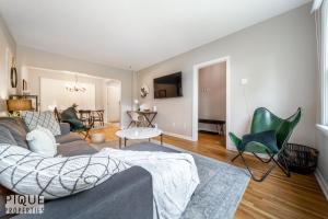 a living room with a gray couch and green chairs at 6 Bed Chic Stylish Home - 5 Mins to U of A & Whyte Ave - Fast Wi-Fi - Free Parking & Netflix in Edmonton