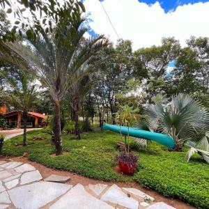 un tobogán azul en un parque con palmeras en Recanto dos manacas en Pirenópolis