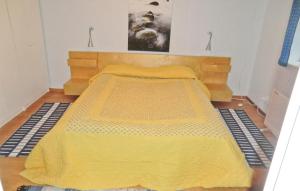 Cama en habitación con colcha amarilla en Rddehof, en Blentarp