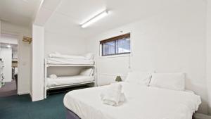 a white bedroom with a bed and a window at Alpine Heights 11B in Mount Hotham