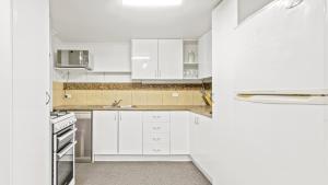 a white kitchen with white cabinets and a sink at Alpine Heights 11B in Mount Hotham