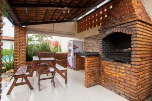 un patio de ladrillo con mesa y horno de ladrillo en Porto das Dunas Casa Temporada Estilo e Conforto, en Fortaleza