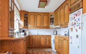 a kitchen with wooden cabinets and a white refrigerator at Gorgeous Home In Bygland in Bygland