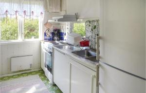 Il comprend une petite cuisine équipée d'un évier et d'une cuisinière. dans l'établissement Amazing Home In Brunskog With Kitchen, à Brunskog