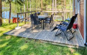 a wooden deck with a table and chairs on it at Beautiful Home In Svanskog With 2 Bedrooms And Sauna in Slirud