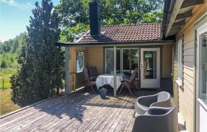un patio con mesa y sillas en una terraza en Nice Home In Jmj With House Sea View, en Torhamn