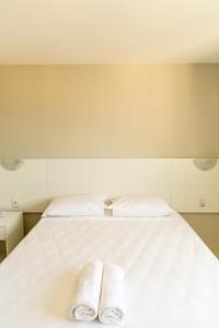 dos toallas están sentadas en una cama blanca en Plattinum Hotel, en Salvador