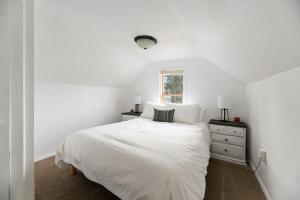 a white bedroom with a bed and a window at The Overlook Nook in Lead