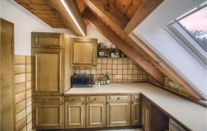una cocina en el ático con armarios de madera y una ventana en 2 Bedroom Amazing Apartment In Schonach, en Schonach