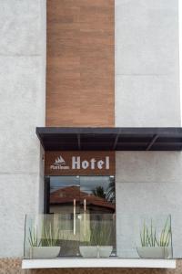 une fenêtre d'un hôtel avec deux plantes en pot dans l'établissement Plattinum Hotel, à Salvador