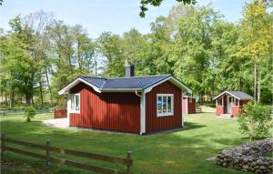 un abri rouge dans une cour avec une clôture dans l'établissement Amazing Home In Slvesborg With 1 Bedrooms And Wifi, à Falkvik