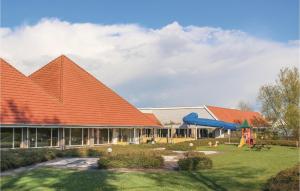 ein Gebäude mit einem orangenen Dach und einem Spielplatz in der Unterkunft Aquadelta Bruinisse-clipper 26 in Bruinisse