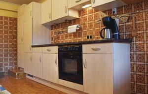 a kitchen with white cabinets and a black oven at Beautiful Apartment In Reifferscheid in Reifferscheid