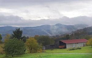 a barn in a field with mountains in the background at Stunning Apartment In Reifferscheid With House A Mountain View in Reifferscheid