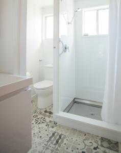 a white bathroom with a toilet and a shower at Ranfurly Motels in Ranfurly