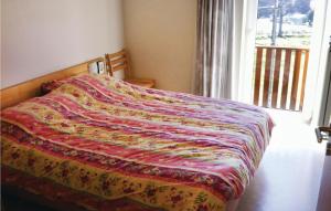 ブルク・ロイラントにあるAmazing Home In Burg-reuland With House A Panoramic Viewのベッドルームにカラフルな毛布が付いたベッド1台