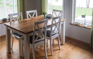 a dining room table with chairs and a wooden table at Lovely Home In Årjäng With Kitchen in Gyltenäs