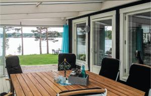 a dining table on a porch with a view of the water at Lovely Home In Årjäng With Kitchen in Gyltenäs