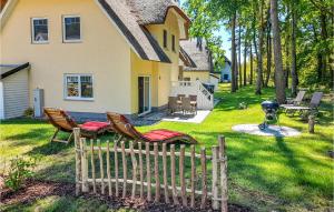 a yard with chairs and a fence in front of a house at Reetdachhaus Kiek In` Wald in Kutzow