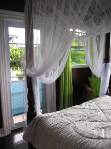 a bedroom with a bed with a canopy and a window at Palm Cottage in Castries