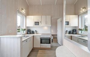 a kitchen with white cabinets and a stove top oven at Frische Brise 18 - Dorf 3 in Priwall