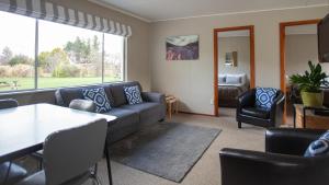 a living room with a couch and a table and chairs at Ranfurly Motels in Ranfurly