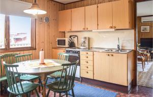 シーピンスリーにあるBeautiful Home In Kpingsvik With 2 Bedroomsのキッチン(テーブル、椅子付)、キッチン(シンク付)
