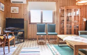 シーピンスリーにある2 Bedroom Lovely Home In Kpingsvikのリビングルーム(木製パネル、テレビ、椅子付)