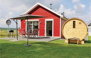 a small red house with a large wooden barrel at Cozy Home In Zerpenschleuse With Sauna in Zerpenschleuse +18 photos