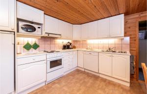 a kitchen with white cabinets and a wooden ceiling at 3 Bedroom Amazing Home In Sandane in Sandane