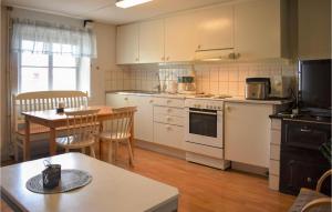 トメリラにあるBeautiful Home In Tomelilla With 2 Bedrooms And Wifiのキッチン(白い家電製品、テーブル付)、ダイニングルーム