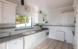 eine weiße Küche mit einem Waschbecken und einem Fenster in der Unterkunft Amazing Home In S,brs De Alportel With Kitchen in Almargens